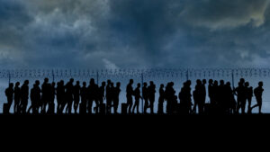 refugees and immigrants standing in front of a border fence